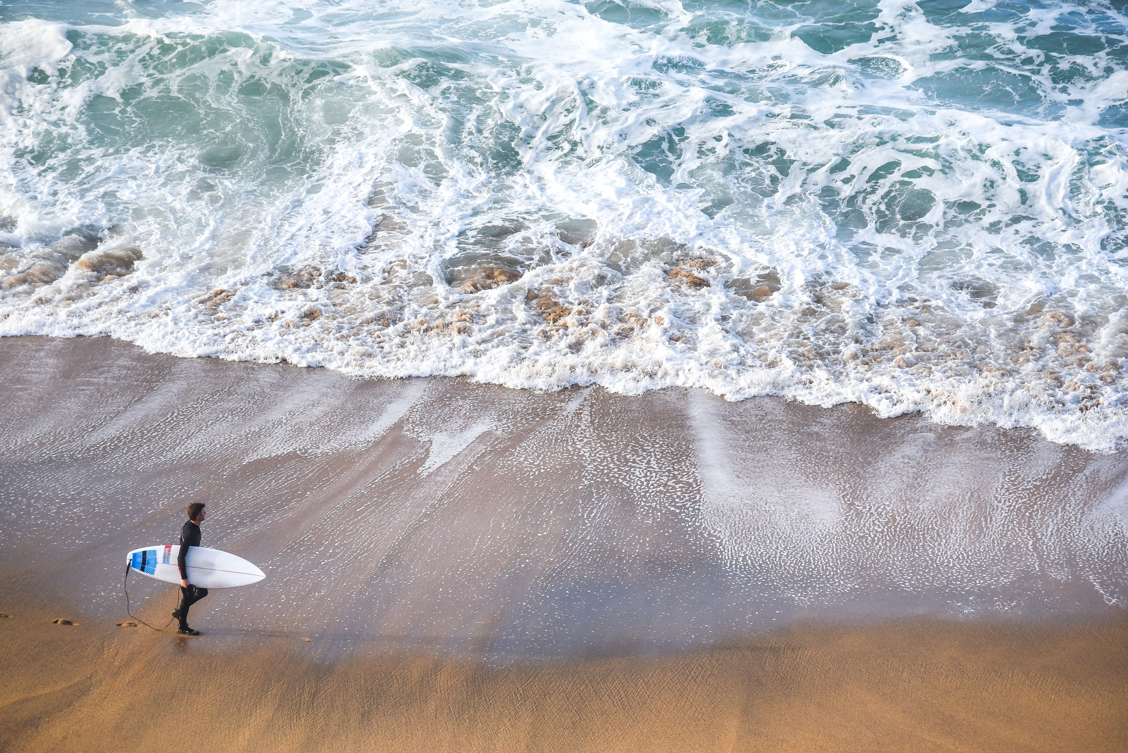 A surfer prepares to enter the surf at Glenaire Beach near Aire River