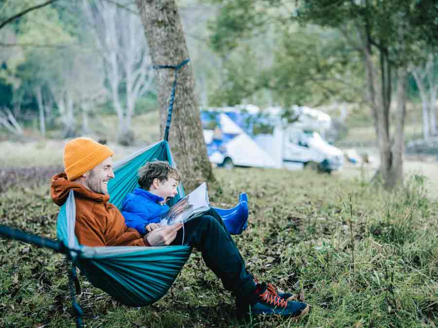 Father and son reading in hammock